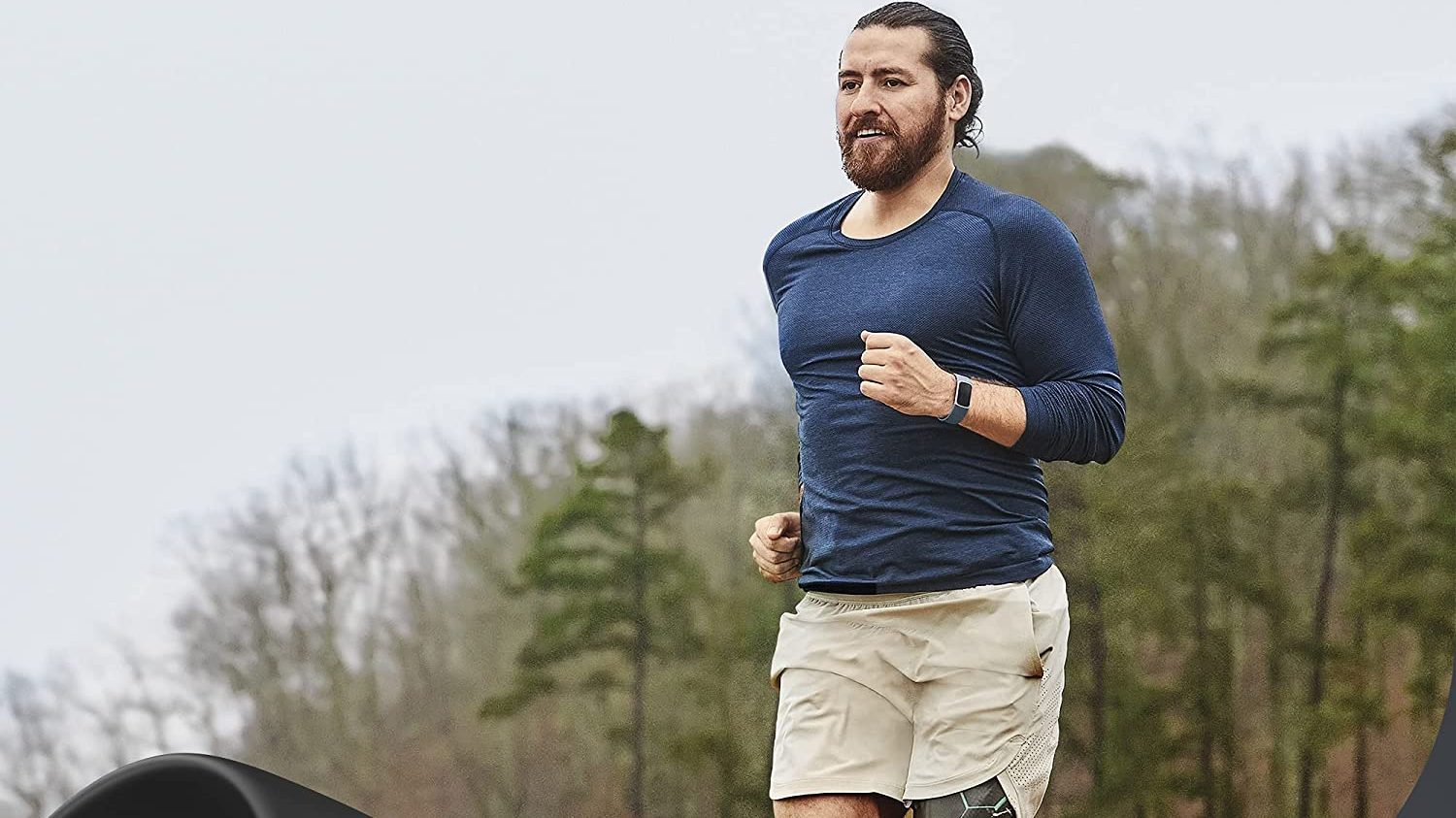 Man jogging with Fitbit on