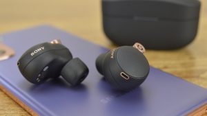 Sony WF-1000XM4 earbuds on a table with a Samsung smartphone